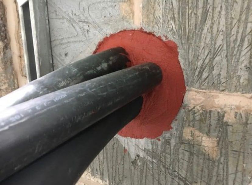 Intumescent mastic sealing cable penetration